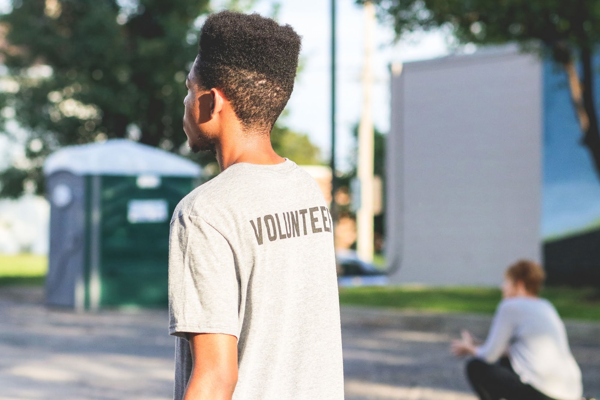 A person wearing a volunteer shirt at an outdoor event
