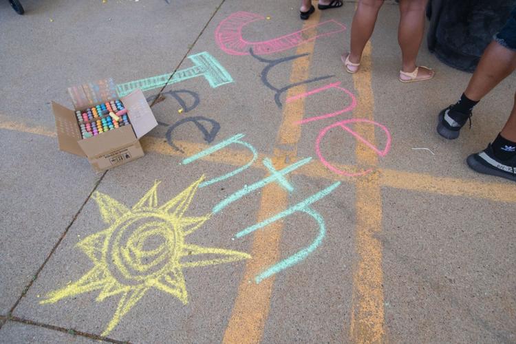 Juneteenth written in colorful chalk on a sidewalk.