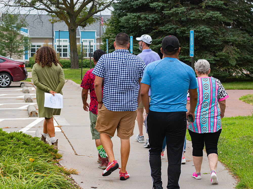 A group of people outside in a neighborhood performing a walk audit.