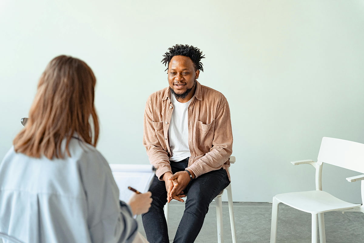 A man sits across from a female therapist to receive mental health help in Omaha.